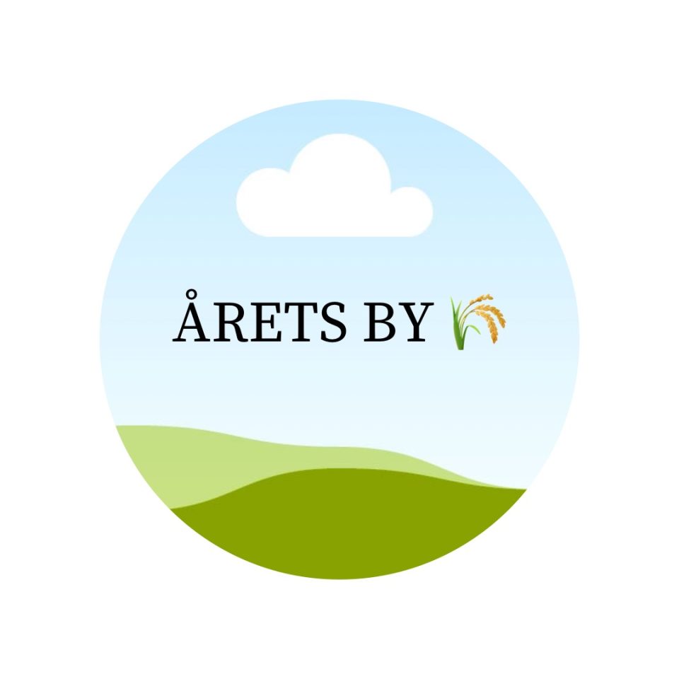 En rund cirkel med texten årets by och en havrekärve